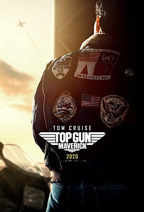 Tom Cruise stands with his back to the camera. Assorted United States military patches are on the back of his jacket. He watches a plane fly off in the distance. The words Tom Cruise and Top Gun Maverick are on the screen. 