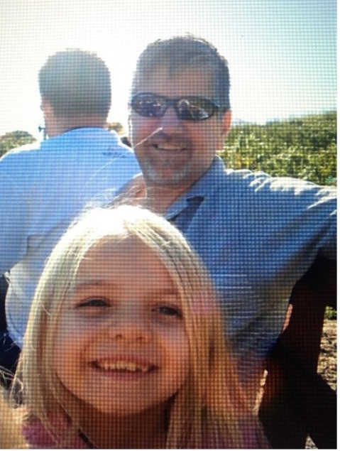 A little girl and her father at the beach.