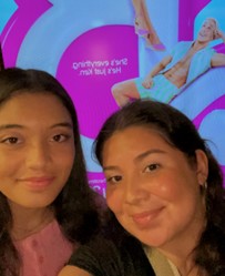 A selfie of Susan Hernandez and her sister in front of the Barbie movie sign.