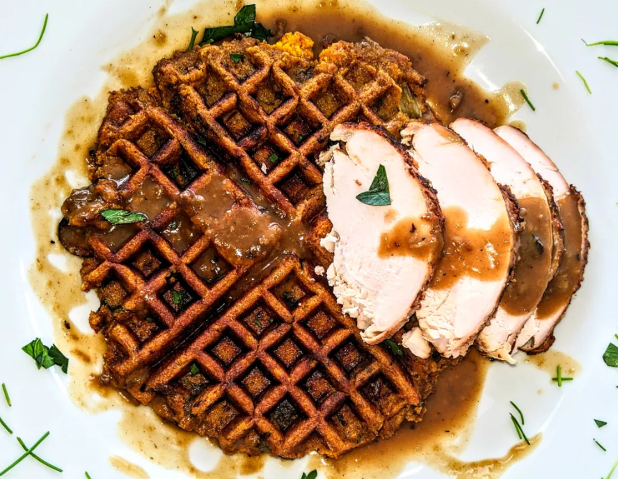 Crispy waffles with sliced turkey and gravy on top.